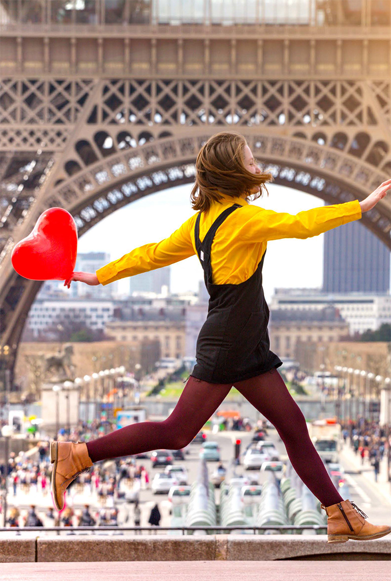 image d'une étudiante à Paris devant la Tour Eiffel avec un ballon rouge